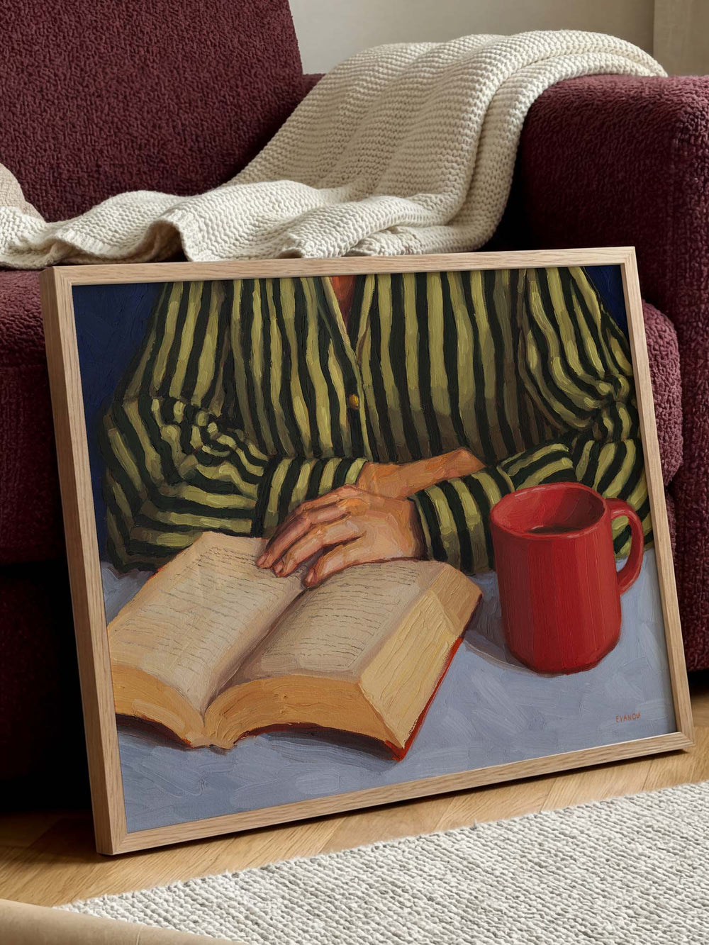 art print of a person with stripy shirt reading a book