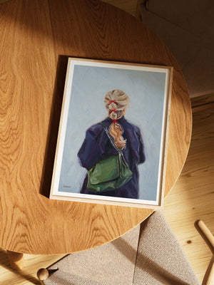 Framed art print of a person with a green bag against a light blue background