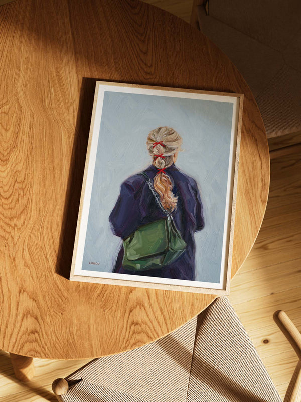 Framed art print of a person with a green bag against a light blue background