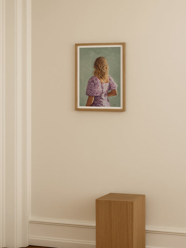 Framed portrait of a woman on a beige wall with a wooden pedestal in the foreground.