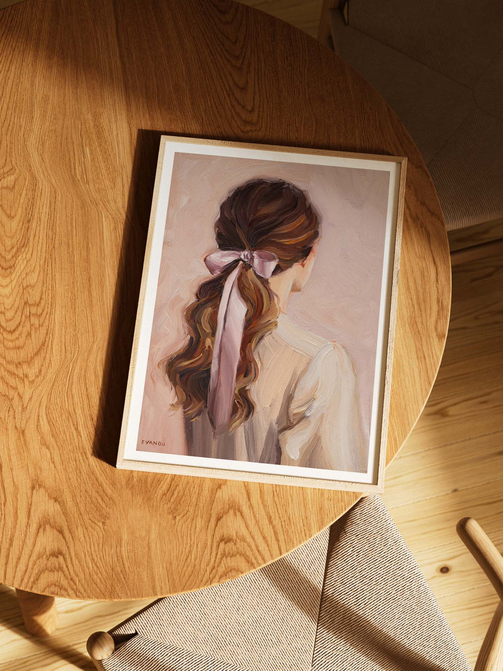 Art print of a woman with long hair tied back with a pink ribbon on a beige background