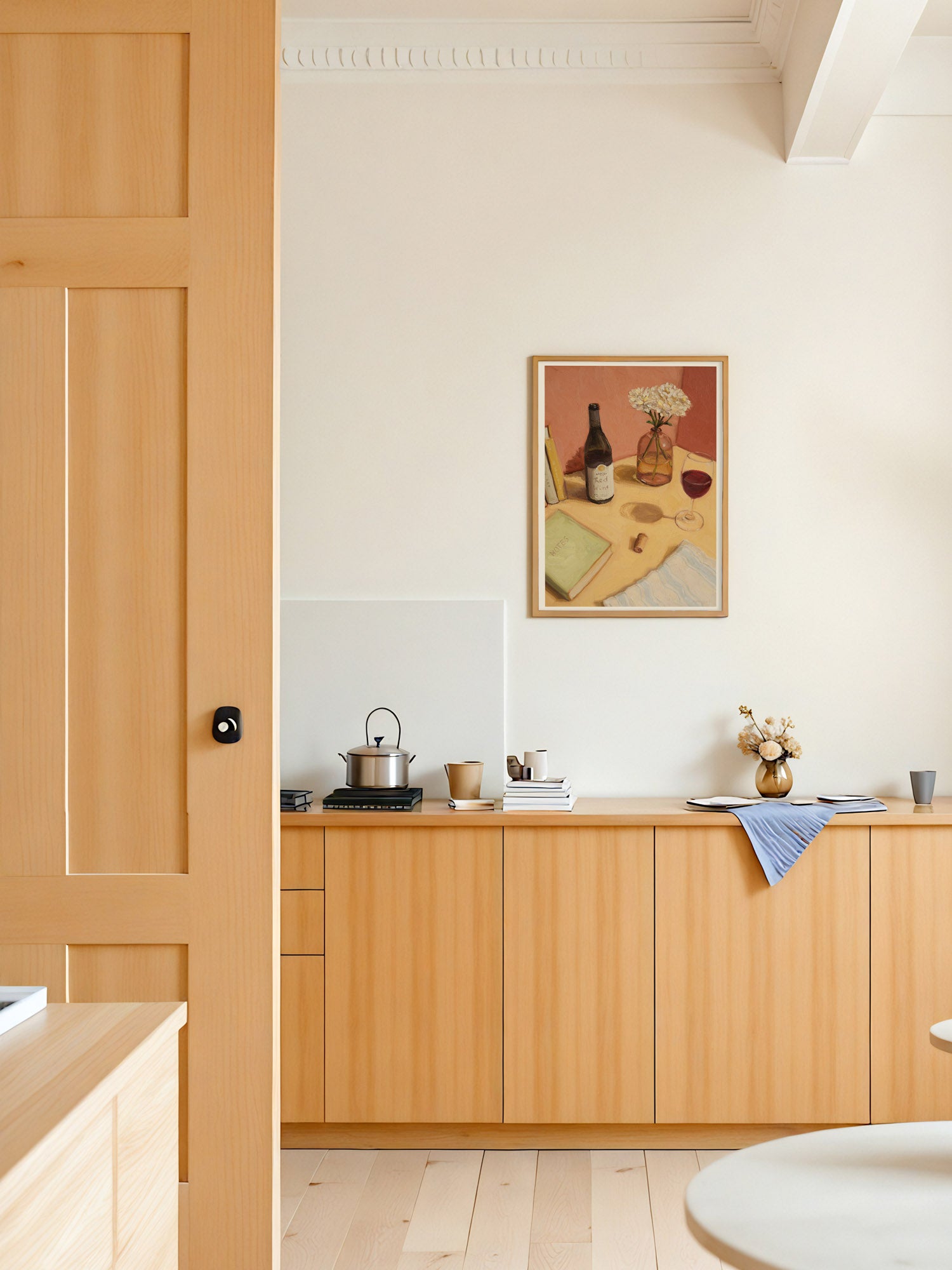 Kitchen interior with wooden cabinets and a painting on the wall.