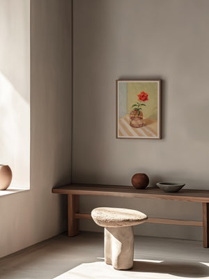 Minimalist interior with a bench, stool, and wall art in a neutral-toned room.
