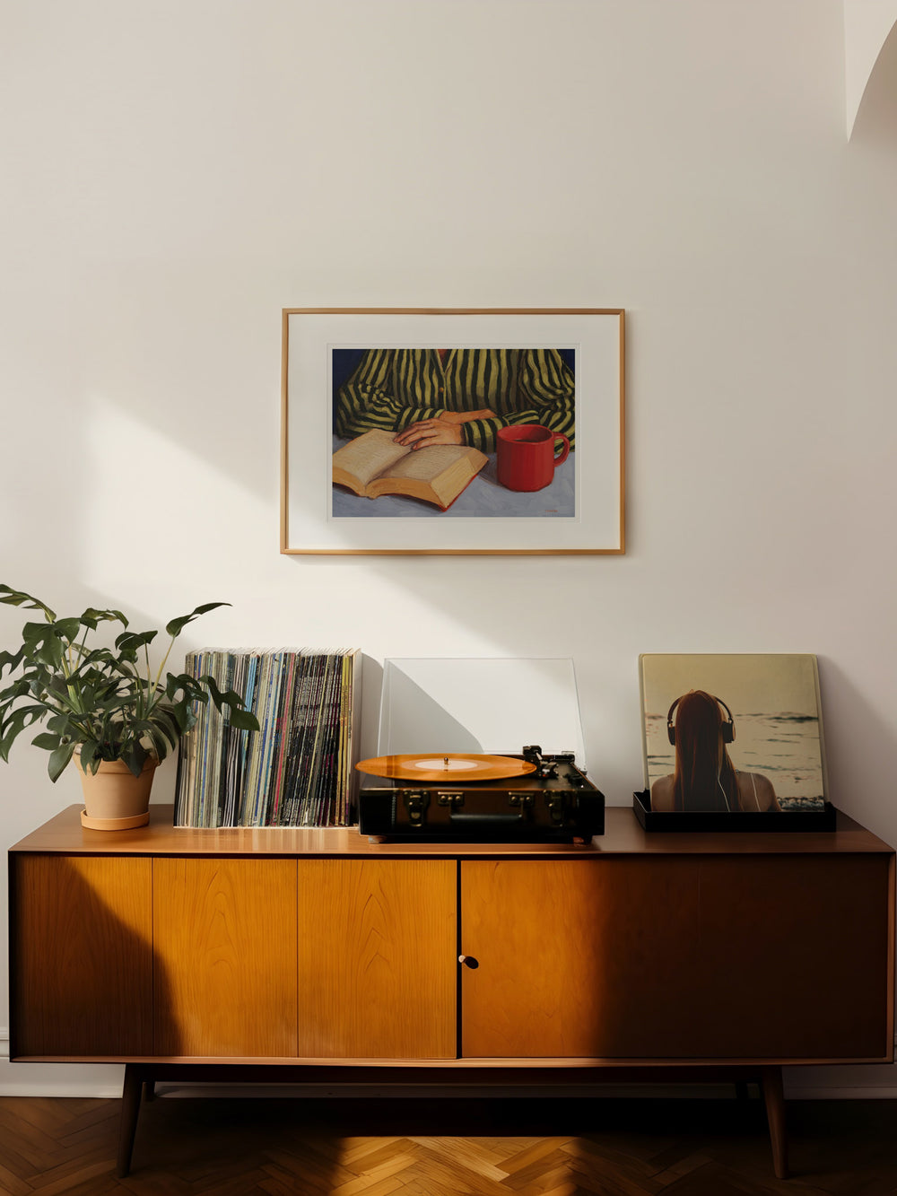 art print of a person with stripy shirt reading a book