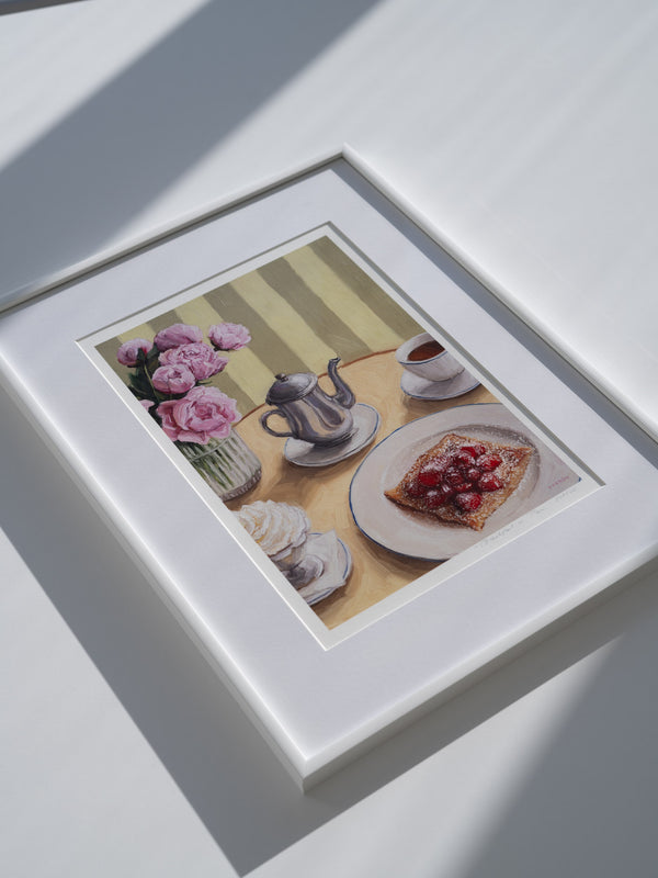 Framed art print featuring a table setting with a silver coffee pot, cup, whipped cream, crepe with strawberries, and peonies in a vase.