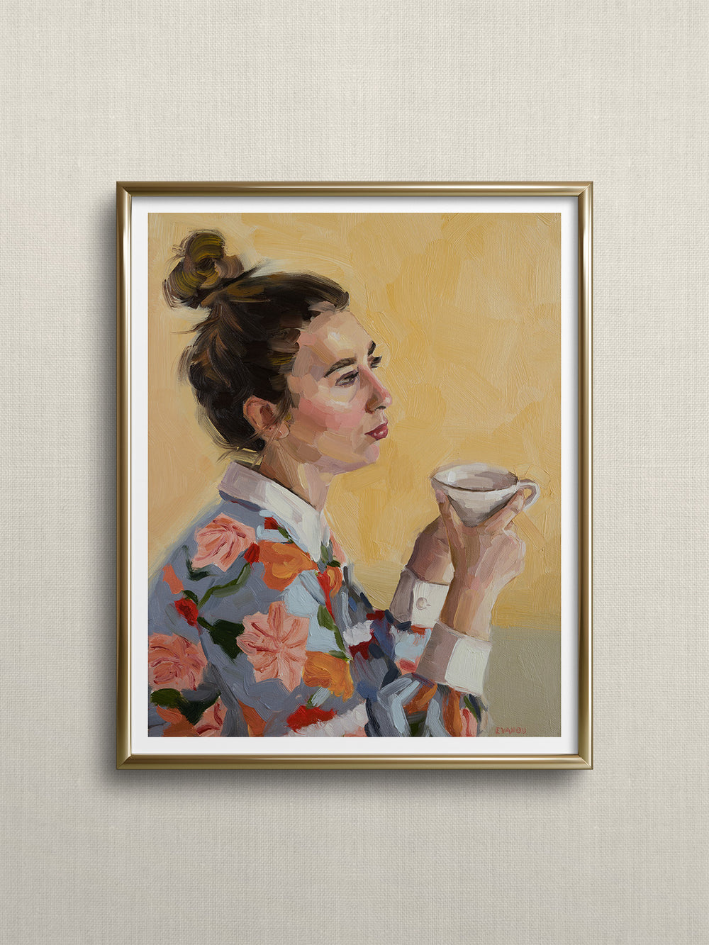A woman, adorned in a vibrant floral shirt, sits comfortably with a cup of tea in her hands, savouring a moment of calm. 